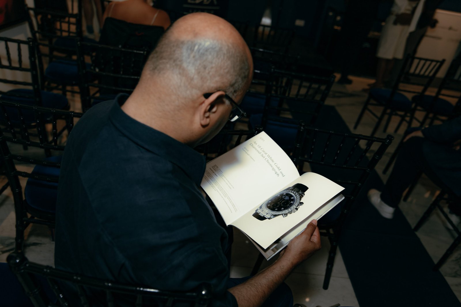 Specialist reviewing artwork, watch documents and luxury items for auction consignment in London
