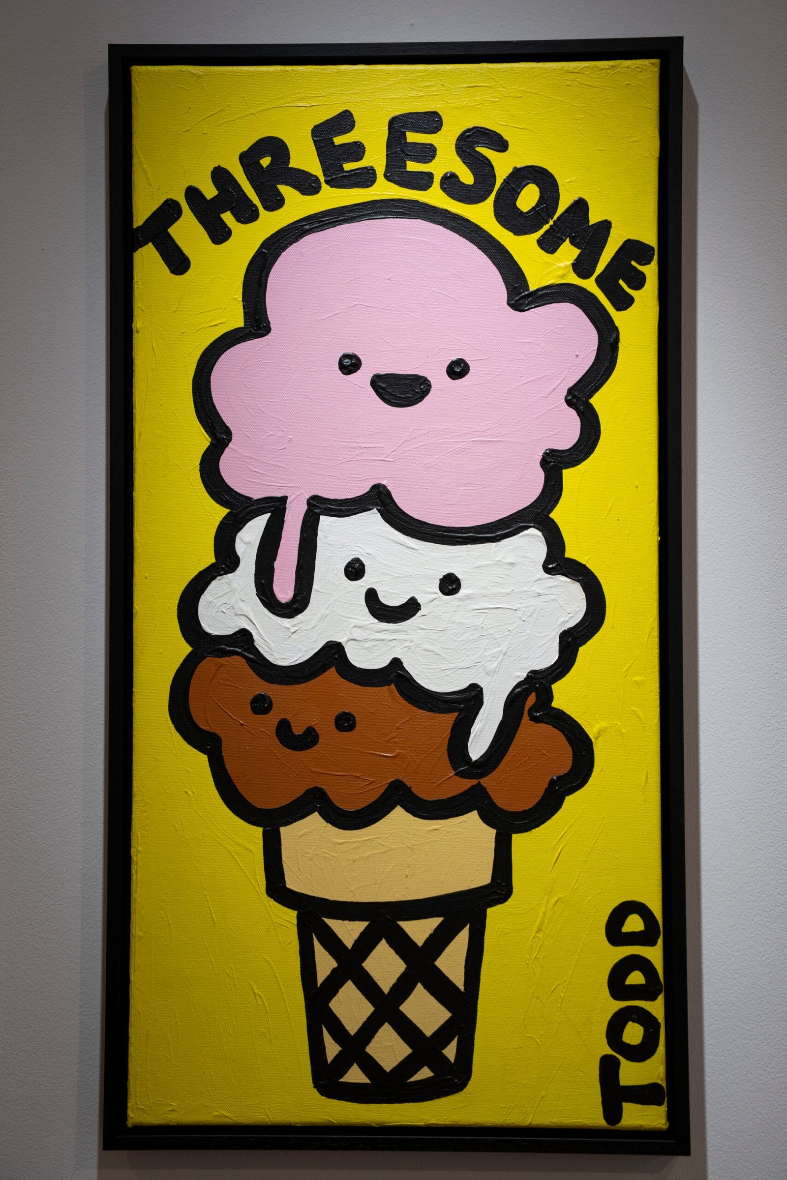 Todd Goldman art featuring three smiling ice cream scoops beneath the word Threesome on a yellow background